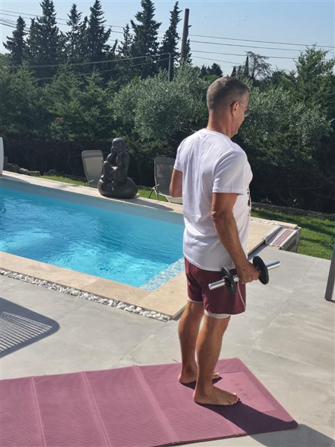 Exercice avec haltère au bord de la piscine